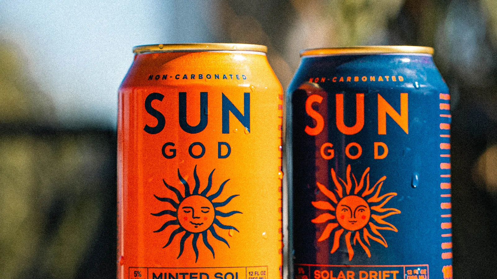 A Minted Sol and a Solar Drift on a sunlit ledge, palm shadows across the wall behind them